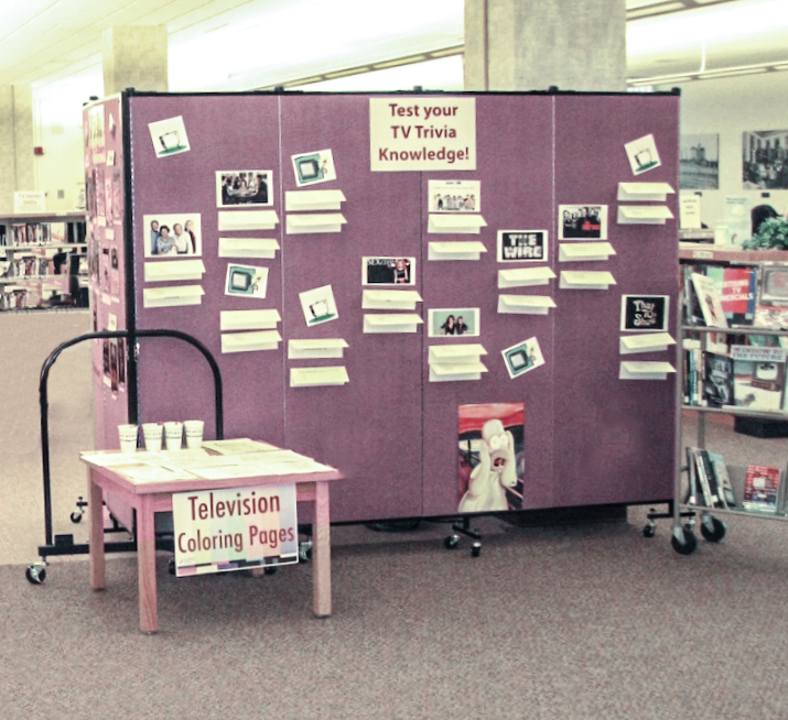 Clues are tacked to a portable wall to create a library TV trivia contest display