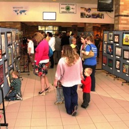 Members of the community look at artwork shown at a community art show