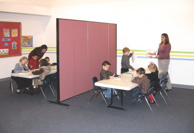 Light duty room divider separates two preschool classes into two within a large shared room.