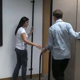A male and female work together to attach a room divider to the wall