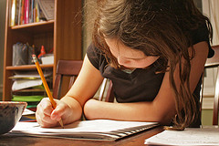 A young girl doing her homework at a kitchen table