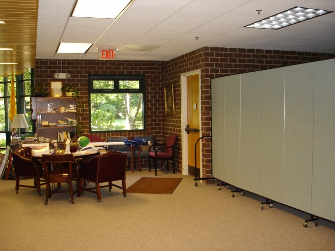A large room is divided in two with a room divider