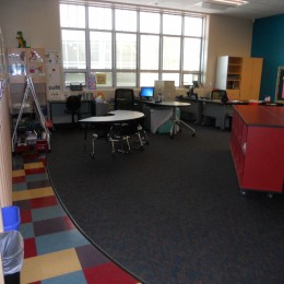 One large classroom cluttered with cabinets and tables and chairs.