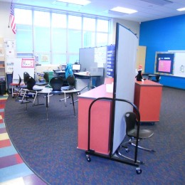 Screenflex Room Divider arranged as a curved wall to divide a classroom into two learning areas.