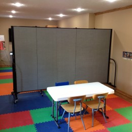 5 panel Screenflex Room Divider creates 2 childcare rooms from one room