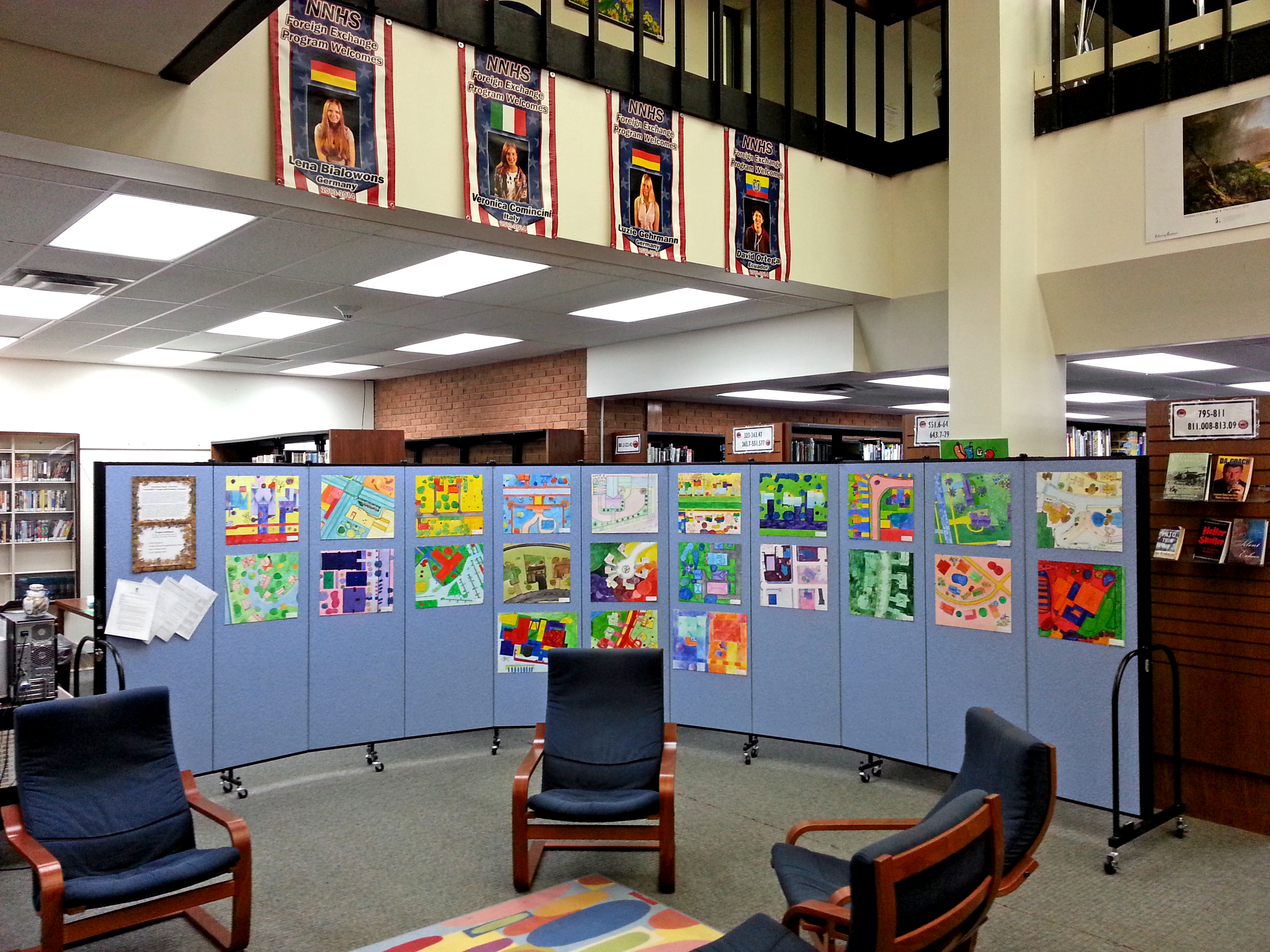 Student artwork tacked to rolling walls and displayed in a school library