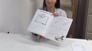 A female shows a booklet on how to submit a plan request drawing from Screenflex.