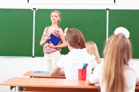 new teacher stands in front of students in the class